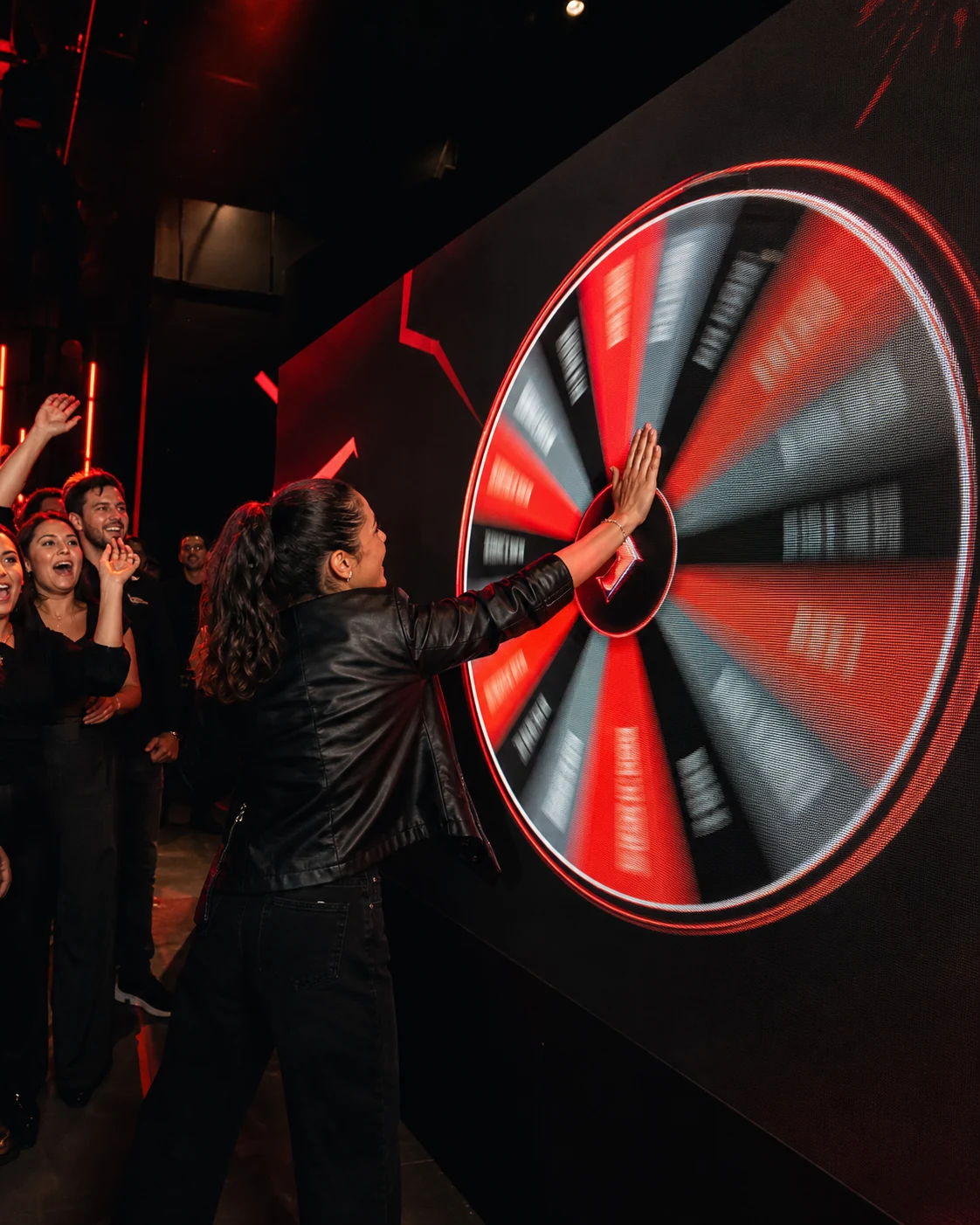Participantes deteniendo una ruleta digital de premios, vista 1